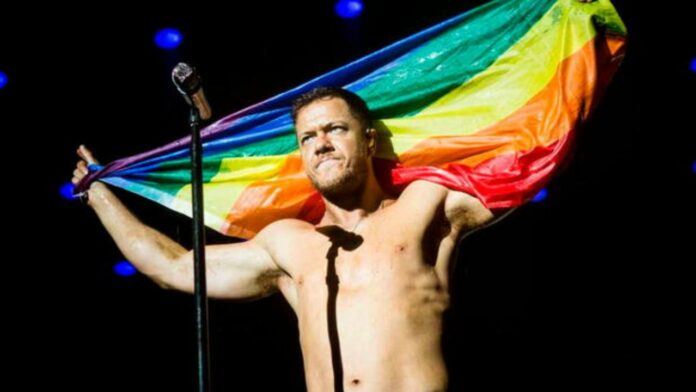 Dan Reynolds vocalista cantante Imagine Dragons bandera LGBT+ sin playera foto concierto