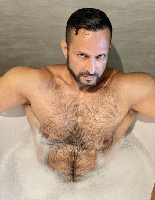 Adam Champ actor sin playera en la bañera.