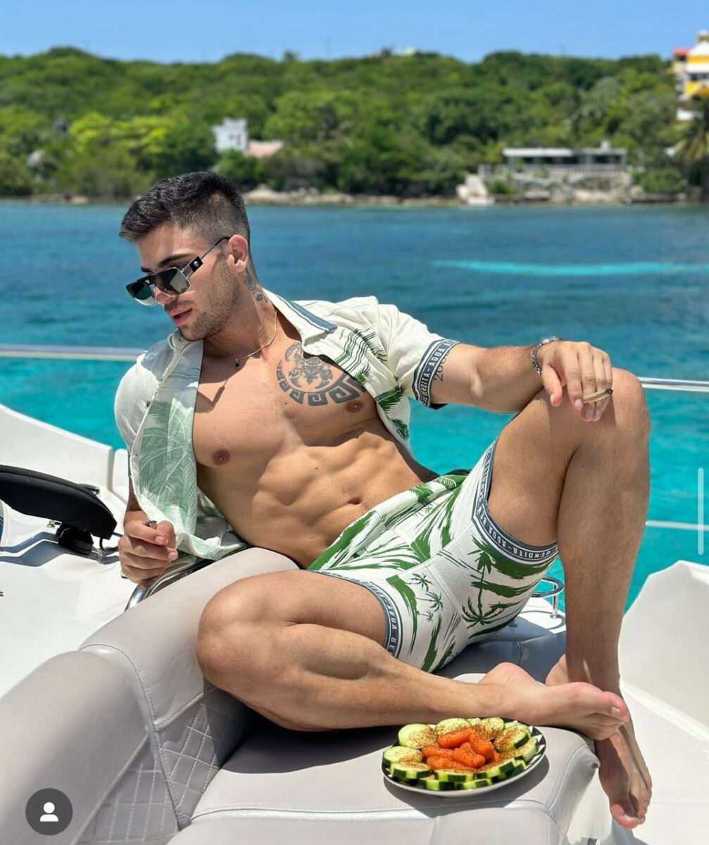 Daniel Montoya en yate con camisa abierta abdomen